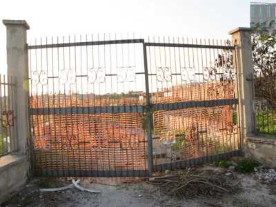 Il vecchio cancello in ferro privo di cartelli posto all'ingresso della necropoli del IX secolo a.C., scoperta durante i lavori di ampliamento del cimitero attuale